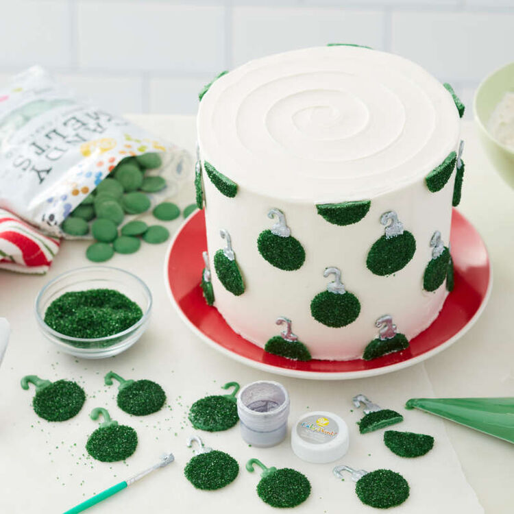 Green Candy Melt wafers covered in green sparkling sugar and attached to a cake to look like ornaments