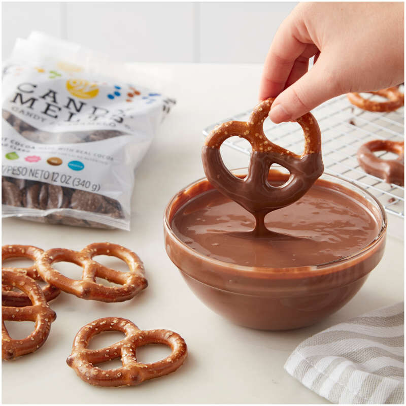 Dipping Pretzels into bowl of melted light Cocoa Candy Melts Candy image number 3