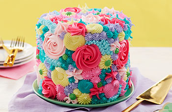 Round cake piped with stars and rosettes to look like flowers