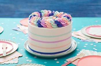 White, round cake with buttercream stripes